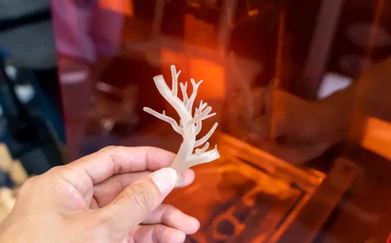 hand with object in shape of medically accurate a human blood vessel printed on 3d printer